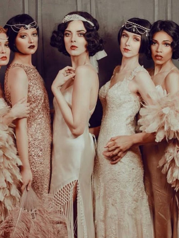 Five women posing in vintage 1920s flapper dresses and beaded headbands.