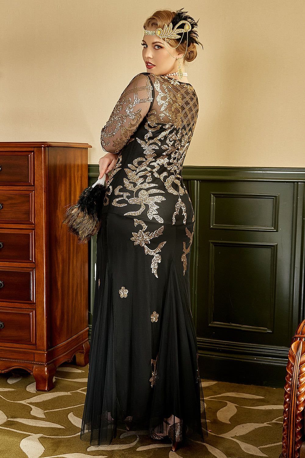 Woman wearing a black and gold sequined 1920s flapper style evening gown and headband.