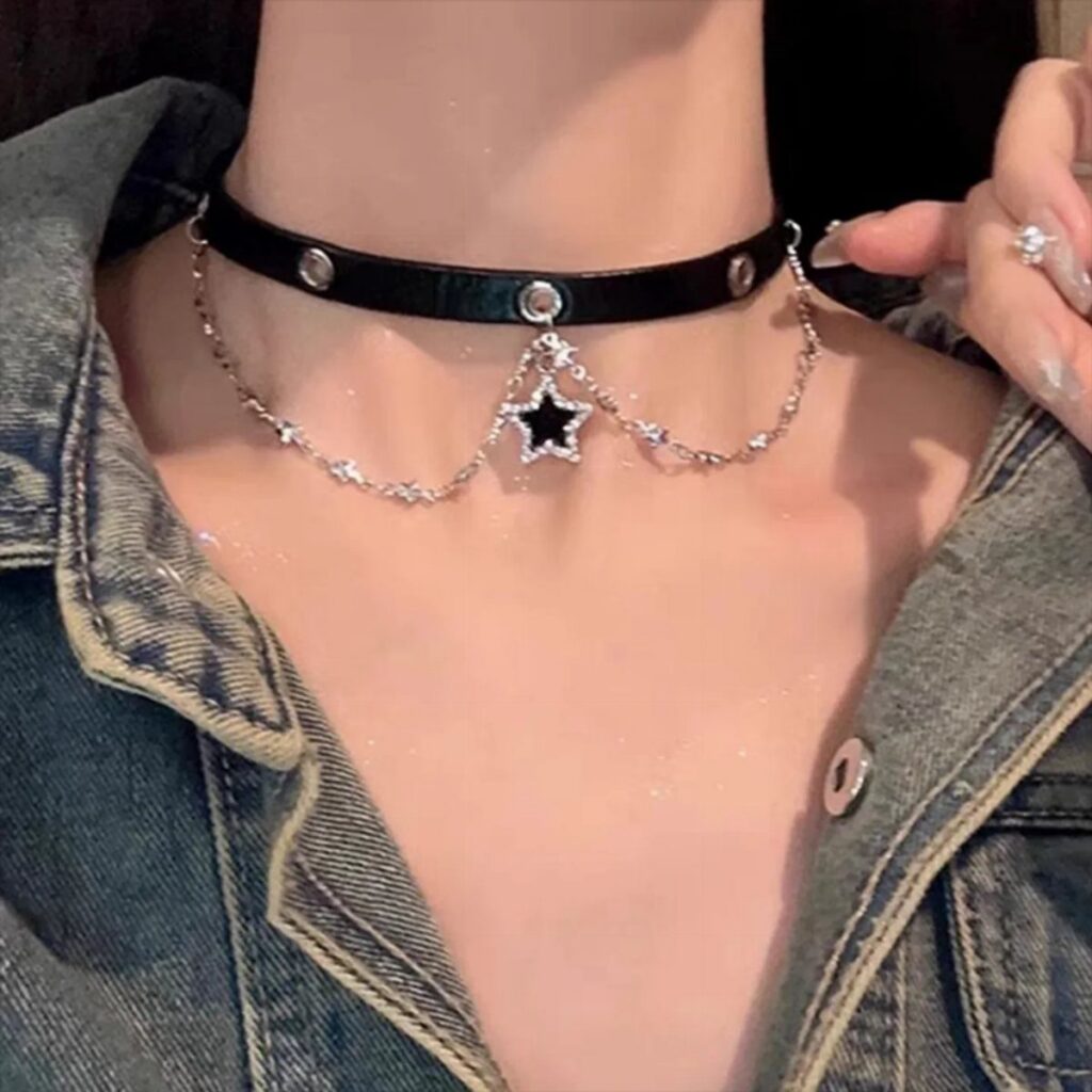 A black leather choker with a silver star charm worn around a person's neck.